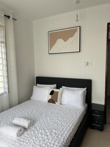 a bedroom with a bed and a picture on the wall at 1bedroom Nyali in Nyali