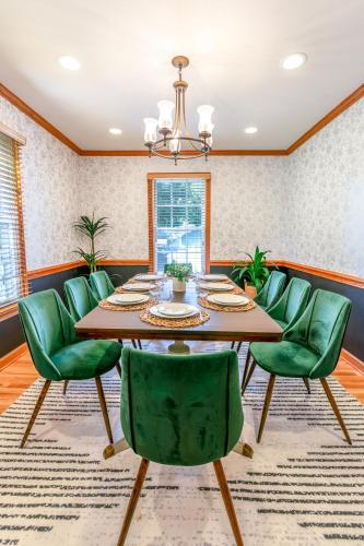 a dining room with a table and green chairs at 4 Beds ,King Bed, Tvs, Kids essentials, office, Grill, Crib, in Bond park ,PNC Arena in Cary