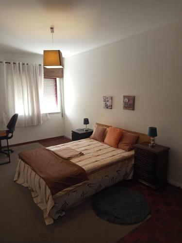 a bedroom with a large bed and a window at As Chaves do Cantinho da Paz in Santarém