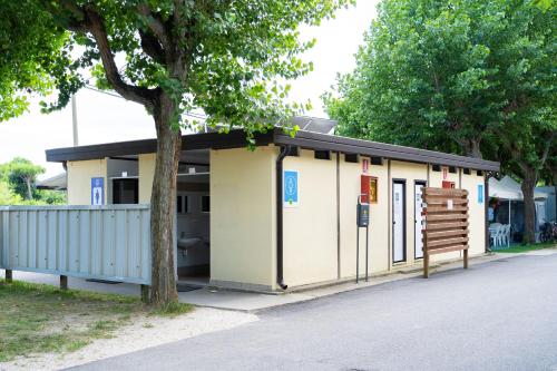a small building with a tree in front of it at Club del Sole Adriatico Cervia Easy Camping Village in Cervia