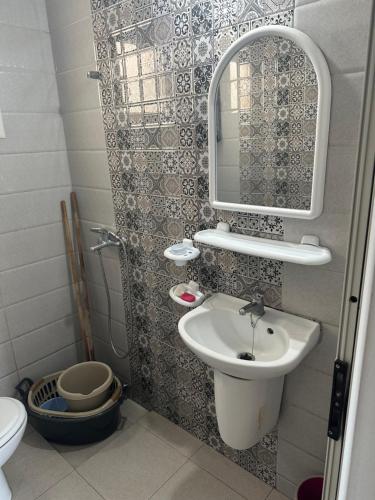 a small bathroom with a sink and a mirror at Liliane Appartement in El Haouaria