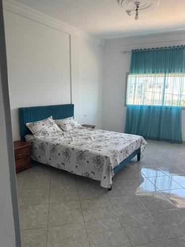 a bedroom with a bed and a window at Liliane Appartement in El Haouaria