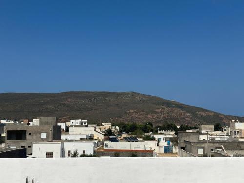 Blick auf eine Stadt mit einem Berg im Hintergrund in der Unterkunft Appartement in El Haouaria