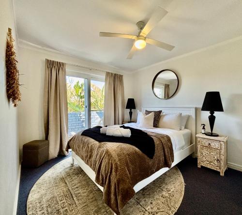 パースにあるLuxury Lagoon Ocean Escape - 2br Sofabed Sleep 6!のベッドルーム1室(天井ファン、窓付)