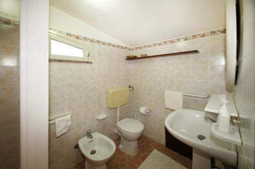a white bathroom with a toilet and a sink at Terrazza sul mare in Santo Stefano di Camastra