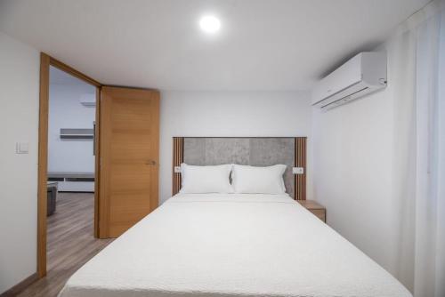 a bedroom with a large white bed in it at Apartamento Paseo Malécon Planta 3 in Monforte de Lemos
