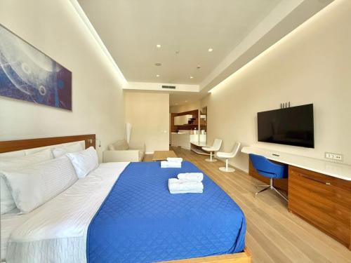 a hotel room with a blue bed and a television at Condo Studio Plaza in Budva