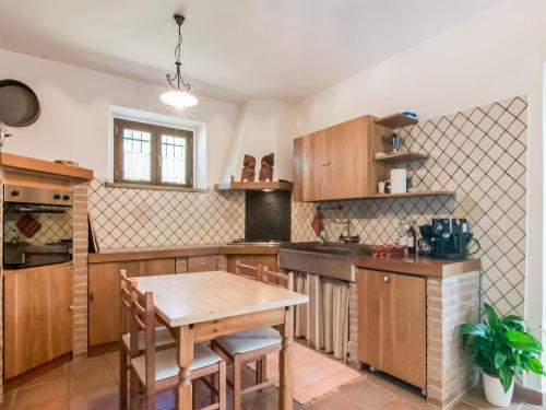 a kitchen with wooden cabinets and a wooden table at Villa in Tavoleto with pool in Tavoleto