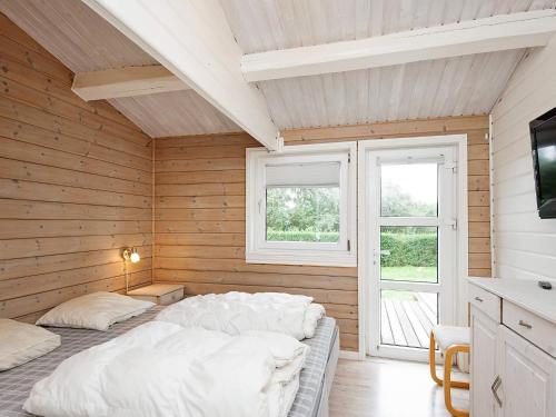 a bedroom with a bed in a wooden wall at 10 person holiday home in Juelsminde-By Traum in Juelsminde
