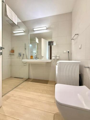 a bathroom with a toilet and a sink and a mirror at Condo Studio Plaza in Budva