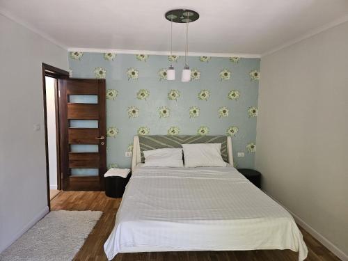 a bedroom with a bed and a blue wall at Apartament modern cu 2 camere in Vaslui, zona Cartier in Vaslui
