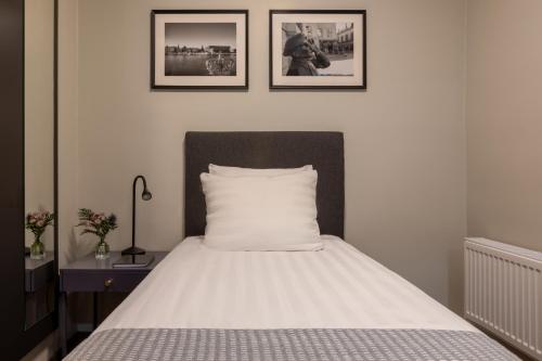 a bed in a bedroom with two pictures on the wall at Bob W Stockholm Gamla Stan in Stockholm