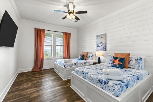 a bedroom with two beds and a ceiling fan at Salty Seabass 4BR Seaside Escape in Port Bolivar