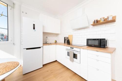 a white kitchen with white cabinets and a microwave at Casa Anik Boutique Home, La laguna in Las Lagunas