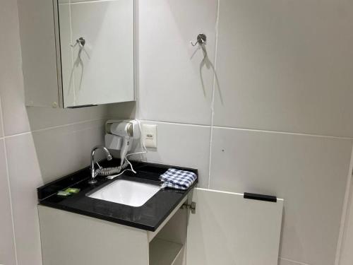 Una pequeña cocina con fregadero y espejo. en Flat na Liberdade próximo do Metrô, en São Paulo