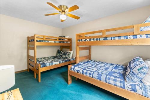 a bedroom with two bunk beds and a ceiling fan at Cozy Retreat awaits w Pool Grill Near Dollywood in Pigeon Forge