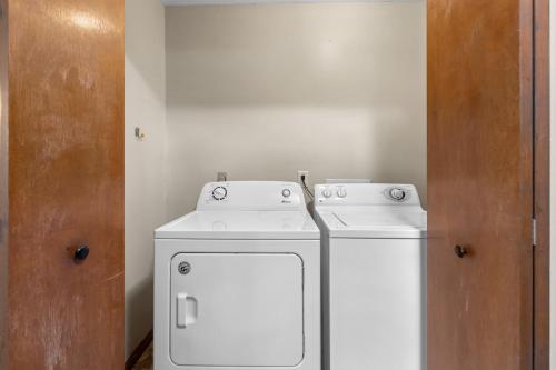 a small kitchen with a white stove and a refrigerator at Cozy Retreat awaits w Pool Grill Near Dollywood in Pigeon Forge
