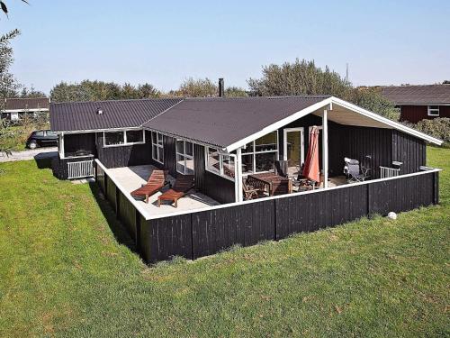 a house with a deck with chairs on it at 4 star holiday home in Hjørring in Lønstrup