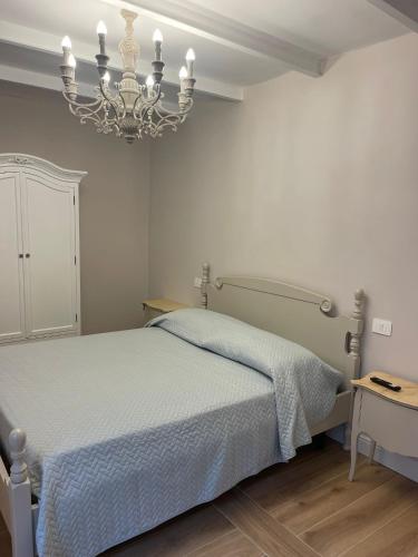 a bedroom with a bed and a chandelier at Maison Simo in Pescasseroli