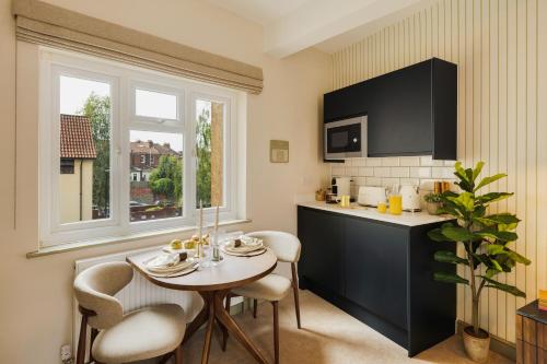 a kitchen with a table and chairs and a table and a window at Hotwells I Your Apartment in Bristol