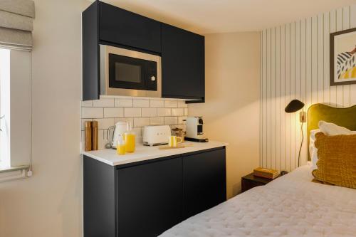 a hotel room with a bed and a microwave at Hotwells I Your Apartment in Bristol