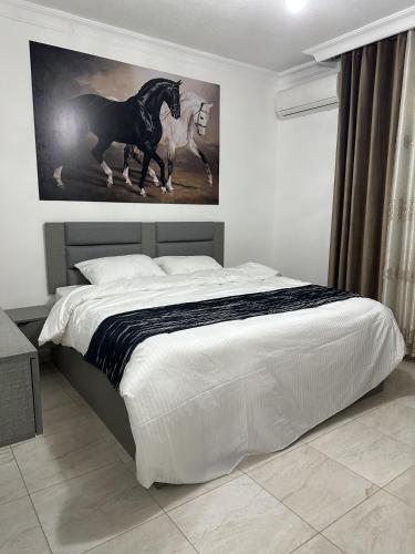 a bedroom with a bed with a painting of a horse at EVANNA SUITE & HOTELs VIP ايفانا للشقق الفندقيه VIP in Amman