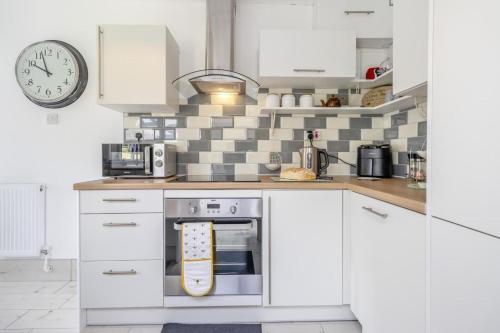 a kitchen with white cabinets and a clock on the wall at 3 Bed in Forden oc-c30173 in Forden