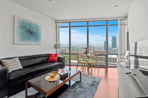 a living room with a black couch and a table at Magnificent 1 Bd High floor view Downtown Toronto in Toronto