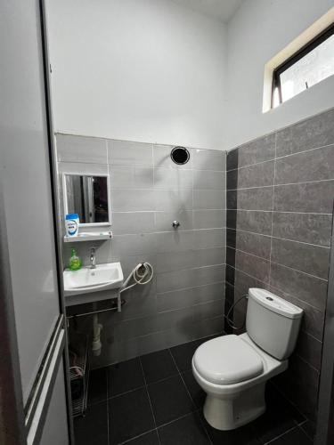 un baño con inodoro y lavabo en AZZR Homestay, en Kuala Terengganu