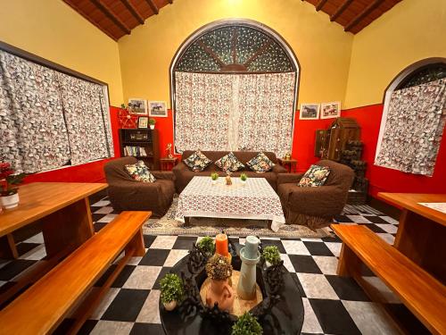 a living room with a couch and a table at LA Address Retreat - The Heritage Homestay in Ooty