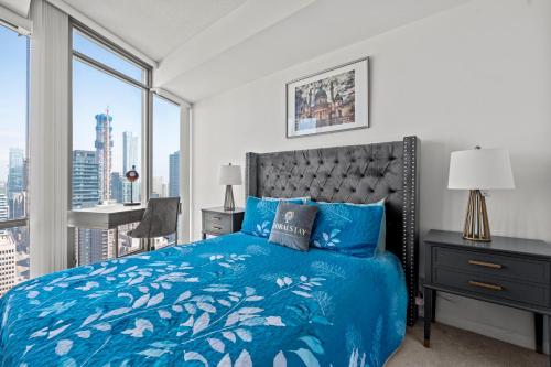 a bedroom with a blue bed and a large window at Magnificent 1 Bd High floor view Downtown Toronto in Toronto