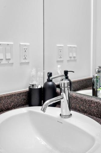 a bathroom sink with a faucet in front of a mirror at Magnificent 1 Bd High floor view Downtown Toronto in Toronto