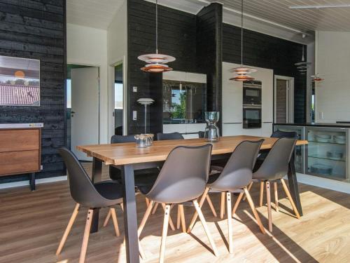a kitchen and dining room with a wooden table and chairs at 5 star holiday home in Hejls in Hejls