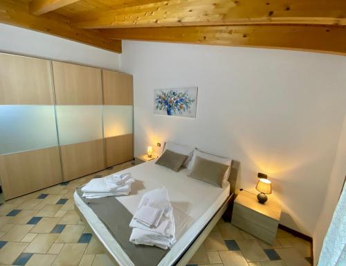 a bedroom with a large white bed in a room at ENJOY HOUSE in Ronchi
