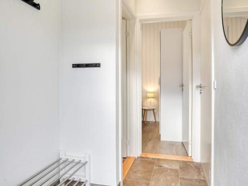 a hallway with white walls and a mirror and a table at 6 person holiday home in Læsø-By Traum in Læsø