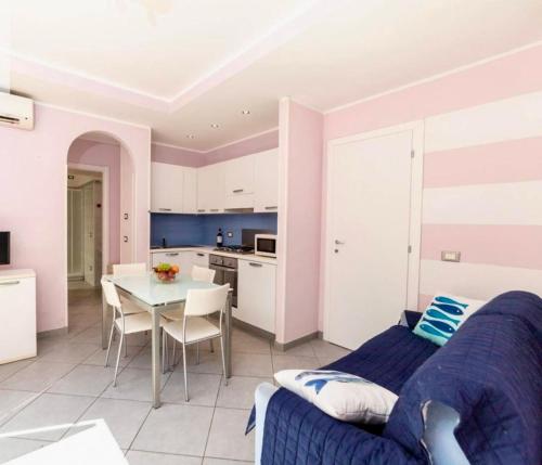 sala de estar con cama, mesa y cocina en La Casetta rosa, en Diano Marina