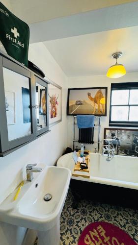 a bathroom with a sink and a bath tub at Retro House by the Sea in Hollington