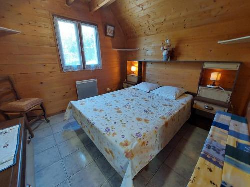a bedroom with a bed in a wooden cabin at La Petite Maison en bois climatisée sud de Sarlat in Vézac