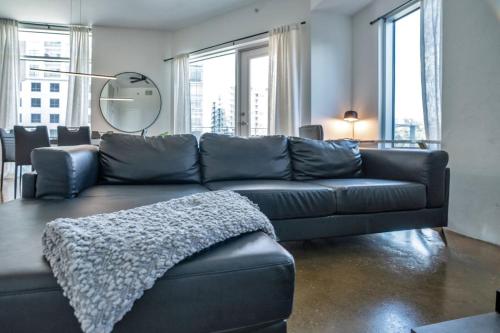 un canapé en cuir noir dans un salon avec des fenêtres dans l'établissement 3 bedroom Corner Suite, à Orlando