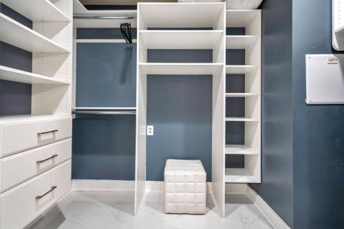 garderoba z białymi półkami i stołkiem w obiekcie Lake Eola Corner 3 BDRM Suite w Orlando
