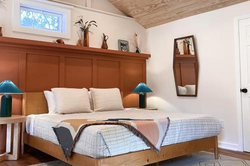 a bedroom with a large bed with a wooden headboard at Madeira Secluded Cottage 5-Min walk to Amphitheater, lighthouse, downtown in Saint Augustine