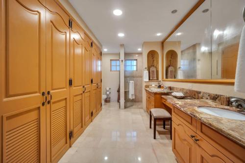 baño grande con 2 lavabos y armarios de madera en Beachfront Premium Ocean View 5 Star Beach View, en Cabo San Lucas