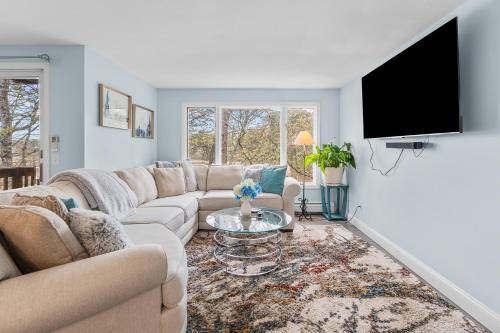 a living room with a couch and a tv at Water View Home with Hot Tub Balcony Pool and Tennis in Mashpee