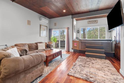 a living room with couches and a flat screen tv at Water View Home with Hot Tub Balcony Pool and Tennis in Mashpee