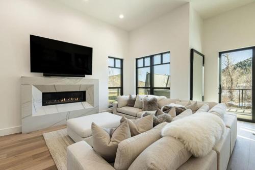 a living room with a large couch and a fireplace at White Pine Luxe Family Retreat with Views in Snyderville