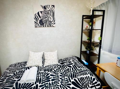 a bedroom with a bed with a black and white at ｄｐ小山町 in Machida