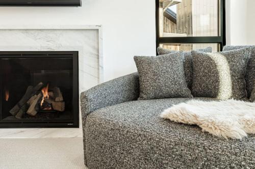 a gray couch in a living room with a fireplace at White Pine Luxe Family Retreat with Views in Snyderville