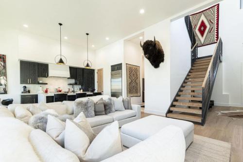 a living room with a white couch and a staircase at White Pine Luxe Family Retreat with Views in Snyderville