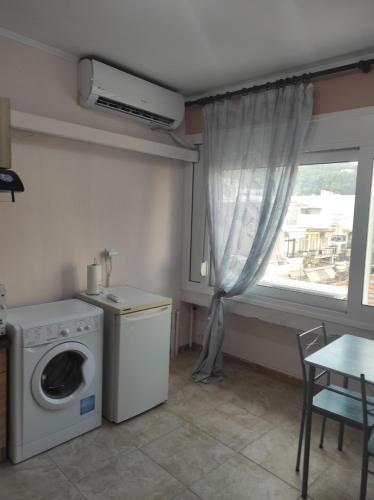 a kitchen with a washing machine and a window at Korina studio in Xanthi