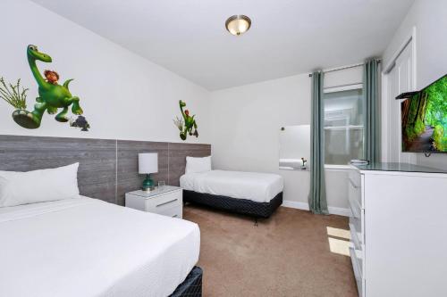 a hotel room with two beds and a tv at Luxury Home With Private Pool And Water Park & Resort Access Near Disney At Encore Resorts Reunion - 240Mn in Kissimmee